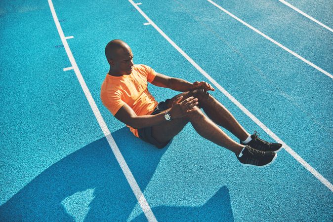 Athlete doing sit ups on a race track