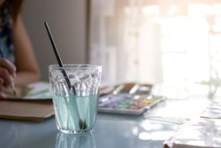 Glass of water to clean paint brushes