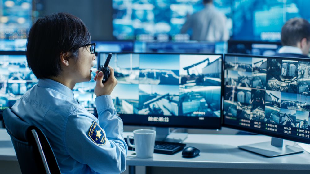 In the Security Control Room Officer Monitors Multiple Screens for Suspicious Activities