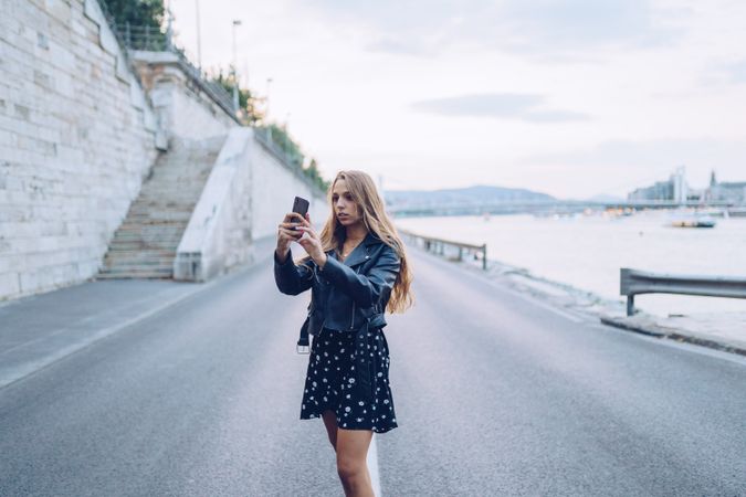 Long haired stylish woman taking selfie with smartphone