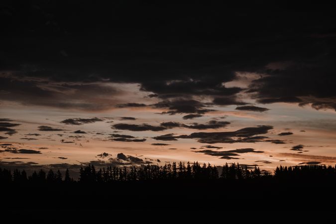 Evening cloudy sky above dark field