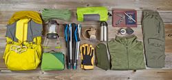 Hiking and camping gear organized on rustic wood
