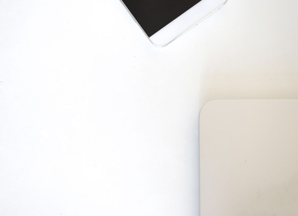 Looking down at laptop and phone on bright desk