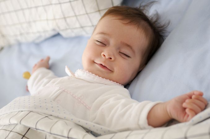 A Peaceful Baby is Sleeping Soundly and Comfortably in Cozy and Soft Bedding Right Now
