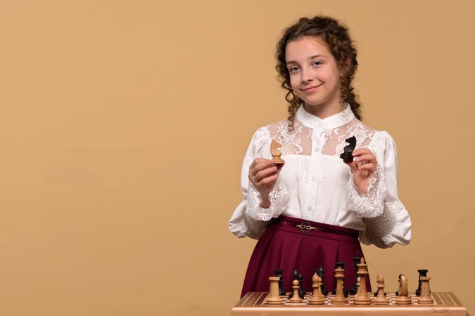 Young girl holding chess knights