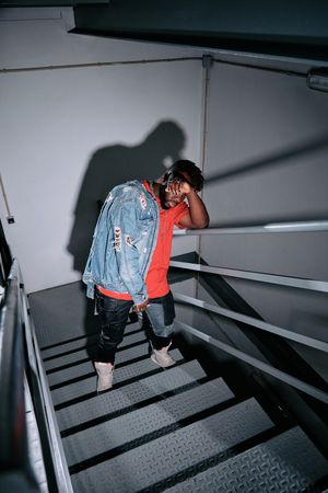 Stylish Black man leaning on metal railing