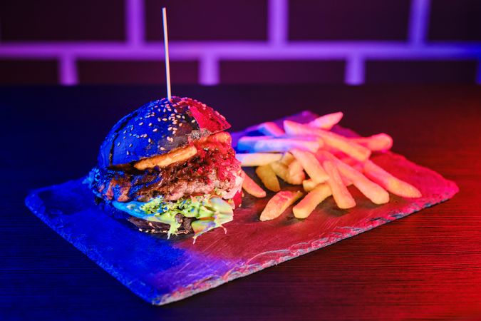 Delicious hamburger and fried potato on board