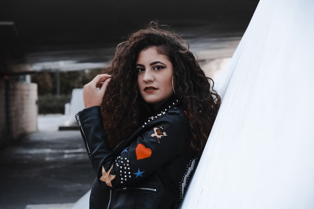Young woman in rocker outfit looking at camera