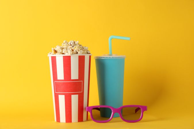 Bucket with popcorn, drink and 3d glasses on yellow background, space for text