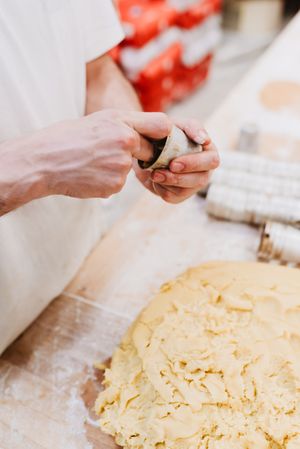 Unrecognizable cook putting pastry dough in cup