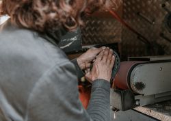 Crop farrier grinding horseshoe