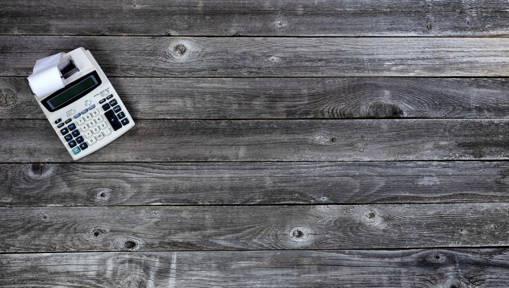 Vintage calculator on old wood desk table
