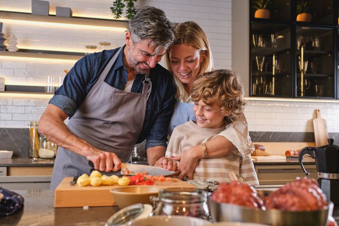 Mother and son watching how father cooking