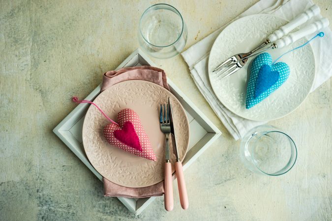 Top view of two table settings for Valentine's day with pink & blue hearts