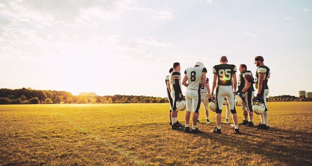A football team discussing their next play on the field