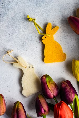 Top view of yellow decorative rabbit with bunch of tulips