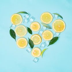 Creative summer background composition with lemon slices, straw and ice cubes