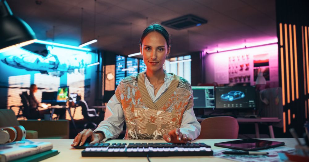 Portrait of a Female Software Developer Writing Code in a Creative Office with Neon Lights.