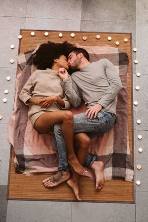 Multiethnic couple kissing on floor
