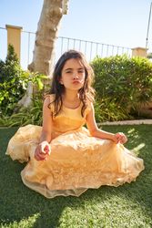 Preteen kid sitting on green grass in summertime and pouting lip