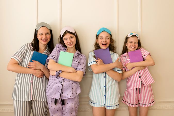 Woman and group girls in striped pajamas holding books