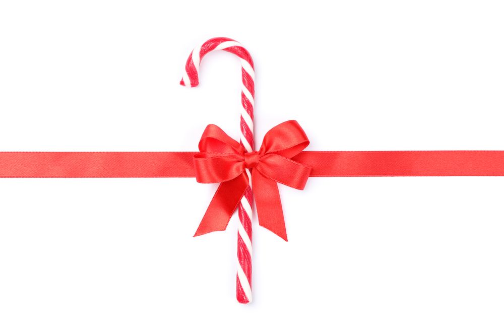 Sweet candy cane with bow isolated on plain background