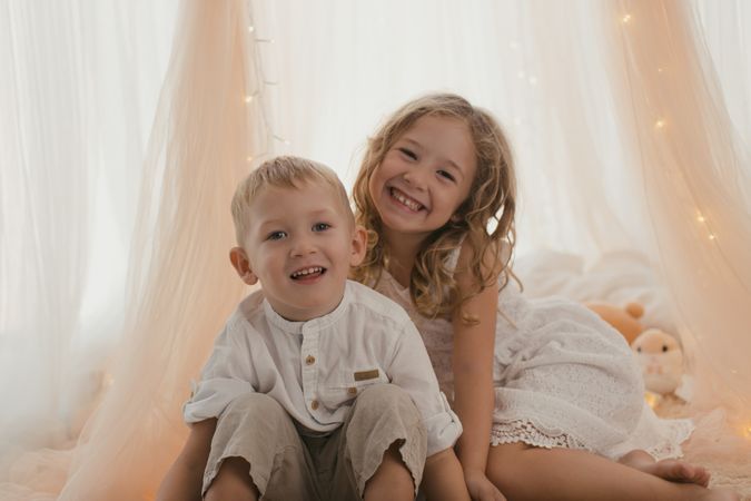 Sister embracing little brother at home