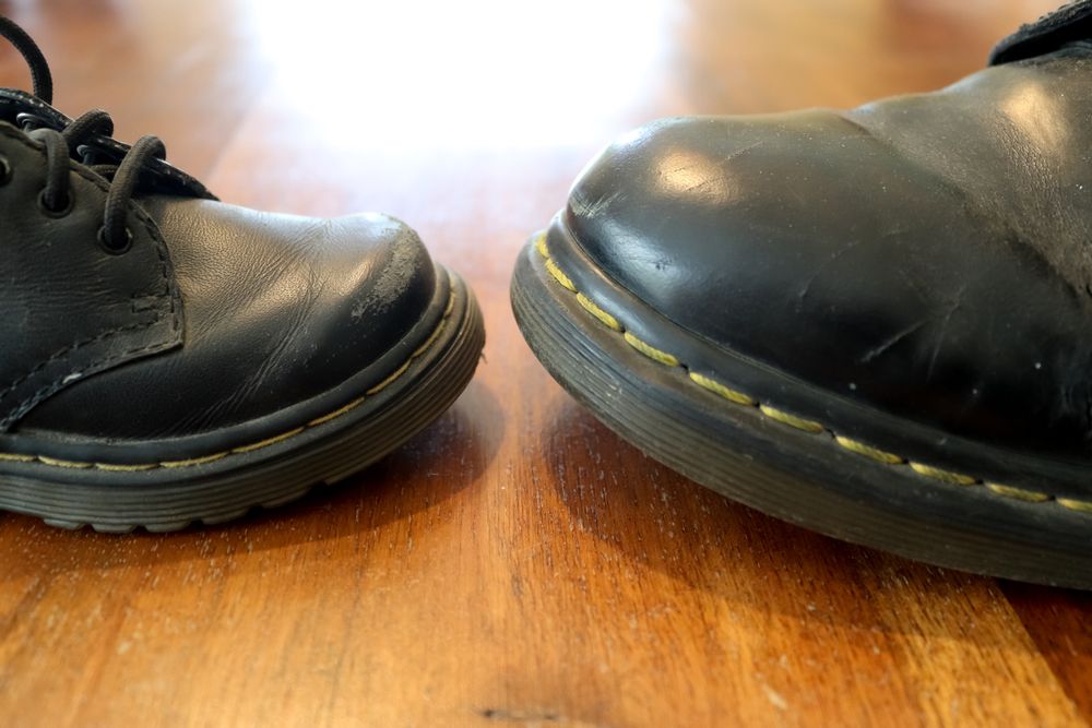 Big and small old leather shoe on a wooden floor