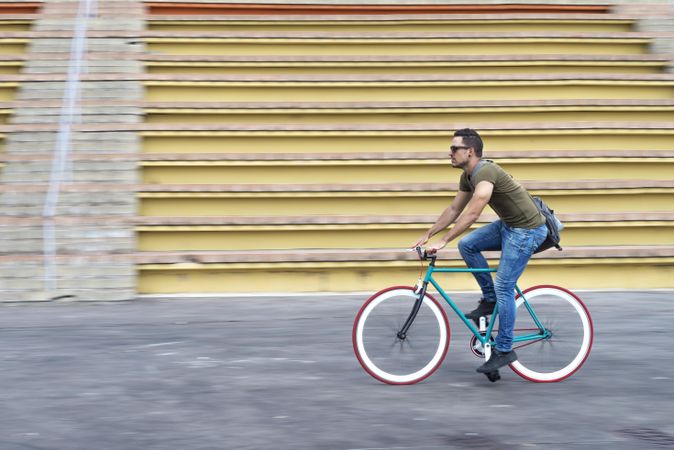 Male on bike with outdoor seating in background