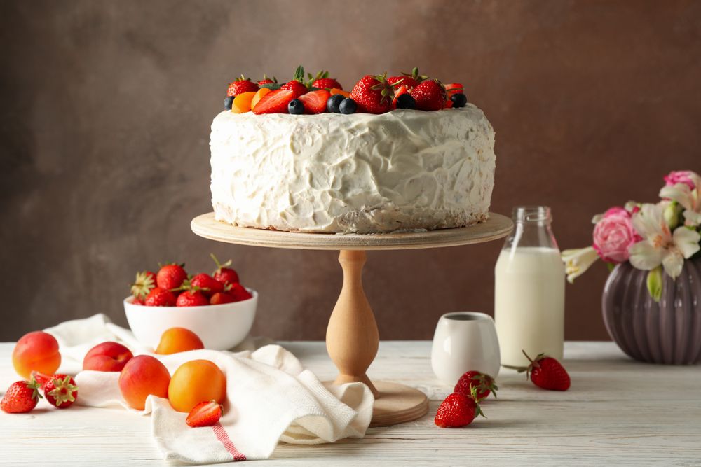 Composition with delicious berry cream cake on wooden table. Tasty dessert