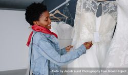 Smiling Black woman shopping for wedding outfit in bridal boutique 0LeMV5