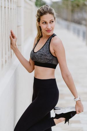 Sportswoman in sports clothing doing workouts at city street