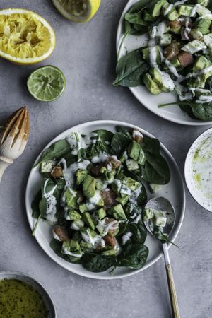 Tasty green salad with salmon on table decorated with citruses