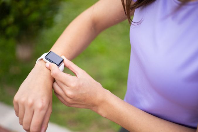 Woman checking a sport smartwatch for running workout outdoors