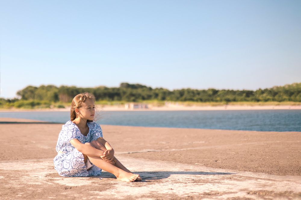 Little girl in a dress on the beach