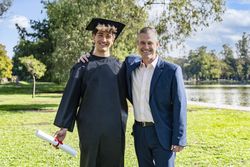 Portrait of a happy graduated young man with his father