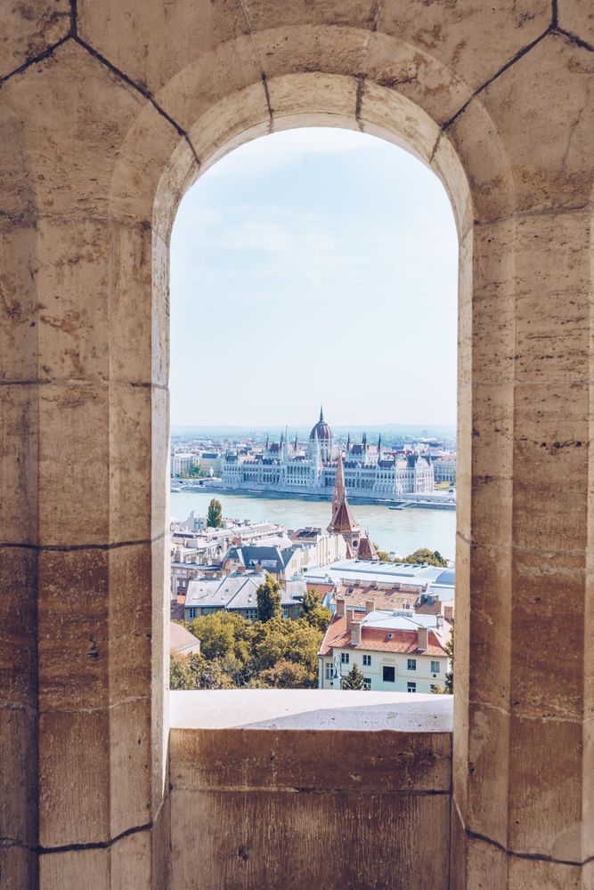 Old stony window in building with view of city