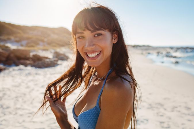 Joyful young woman posing at the beach