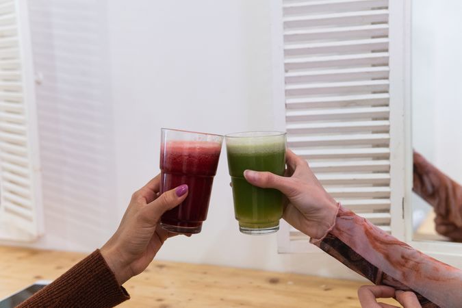 Anonymous diverse women drinking smoothie in bar