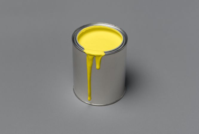 Can of yellow paint on gray background