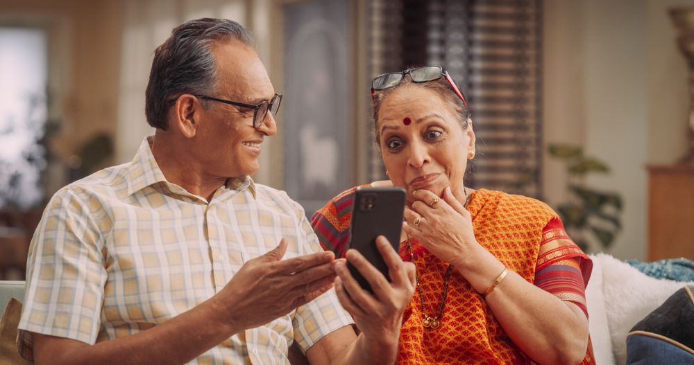 Amazing Older Indian Couple Using Smartphone for Video Call at Home