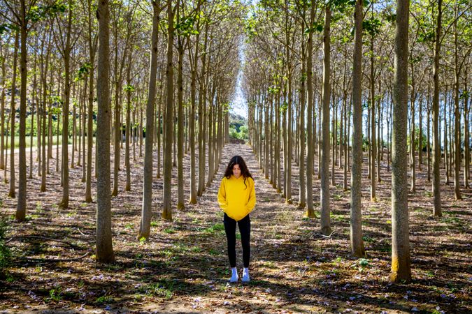 Sporty young woman standing in forest