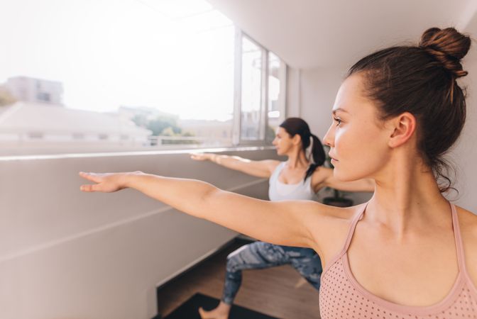 Women doing yoga in warrior pose at studio