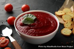 Bowl of tomato soup with crackers and spoon 5qJlq4