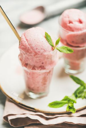 Close up of homemade strawberry yogurt ice cream with fresh mint, vertical composition