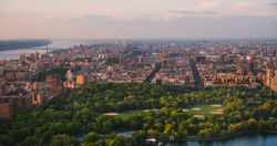 New York Cityscape at Sunset. Aerial Shot from a Helicopter. Modern Skyscraper Buildings Around Central Park in Manhattan Island. Focus on Nature, Trees and Lakes in the Park in the City