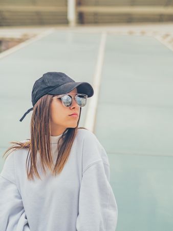 Young woman with glasses standing against wall