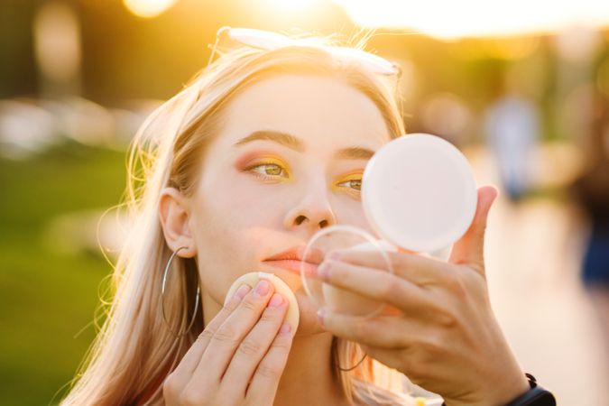 Woman fixes makeup on street