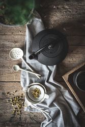 Round teapot and spoons with bowl on linen cloth