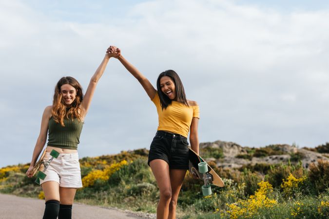 Cheerful diverse women walking on the road